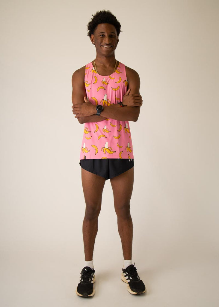 Model is wearing Chicknlegs men's runner singlet in the pink bananas design, facing front and posing while crossing his arms.