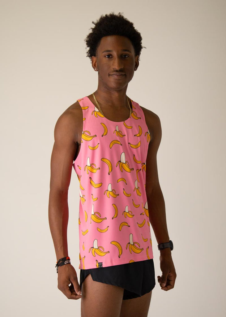 Model is wearing Chicknlegs men's runner singlet in the pink bananas design, facing right.