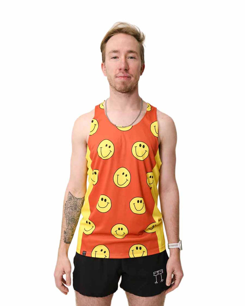 Runner is wearing ChicknLegs in the men's performance singlet with yellow side panels. The print has yellow smiley faces on it with an orange background.
