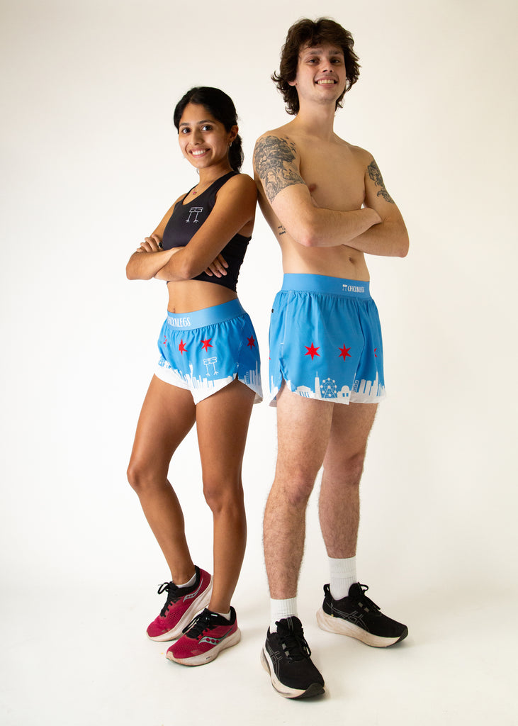 Two runners are shown wearing ChickLegs men and women's 1.5 in split running shorts and 4 in split running shorts in the Chicago Style Skyline. It has blue, red and white on it, great for running in the city and has pockets.