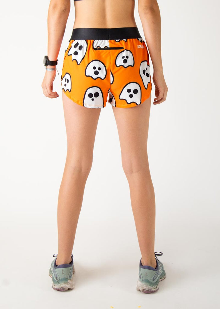 The model is a runner wearing Chicknlegs women's 1.5 inch split running shorts in the Ghosts design, facing  away from the camera to show the back view.