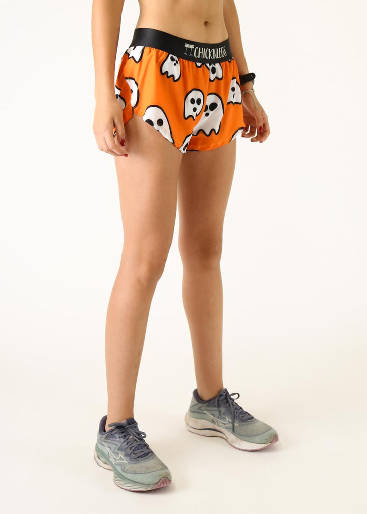 The model is a runner wearing Chicknlegs women's 1.5 inch split running shorts in the Ghosts design, facing right.