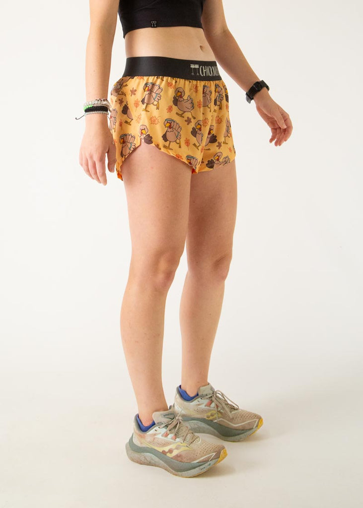 The model is a runner who is wearing Chicknlegs women's 1.5" split running shorts in the pardoned turkey design, facing right.
