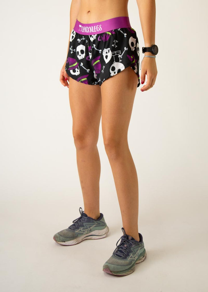 Model is a runner wearing Chicknlegs women's 1.5" split running shorts in the Skulls design, facing left.