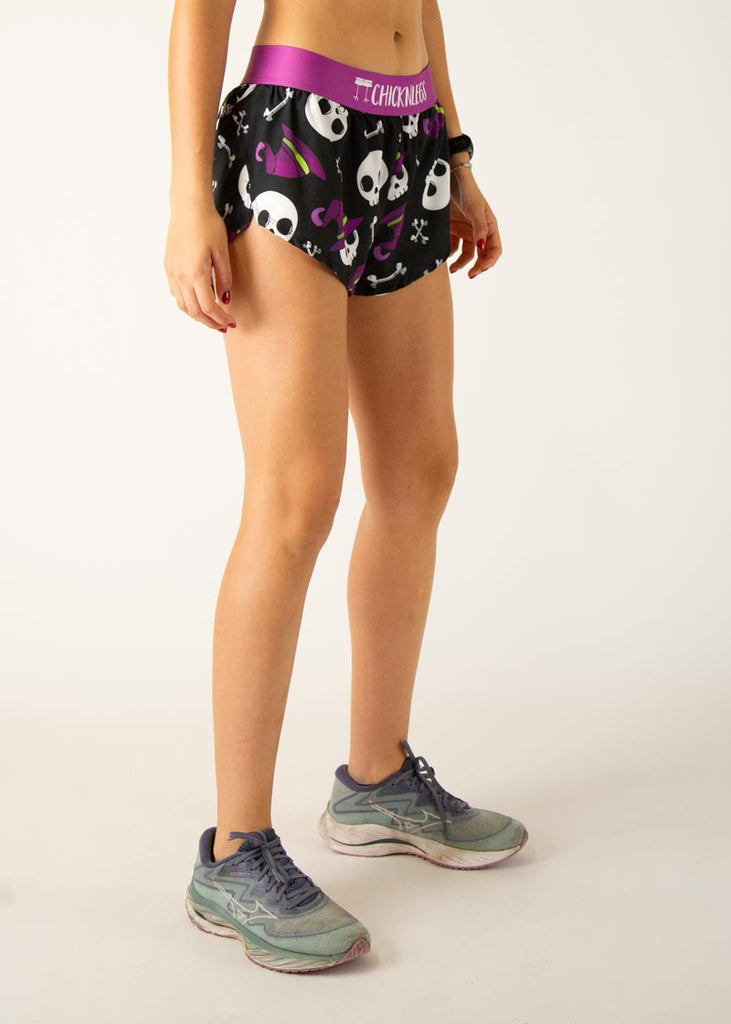 Model is a runner wearing Chicknlegs women's 1.5" split running shorts in the Skulls design, facing right.