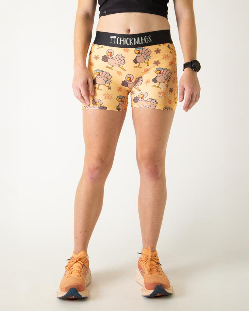 Runner is wearing ChicknLegs in the women's 3 in compression spandex shorts in the pardoned turkey design. The print has thanksgiving turkeys on it with orange leaves for fall. Great for turkey trot runs.