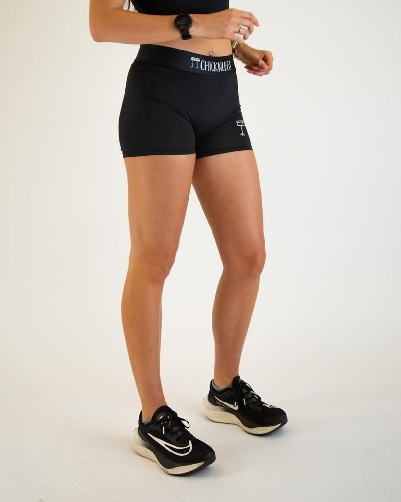 Runner is wearing ChicknLegs in the women's 3 in compression spandex with pockets in the solid black.