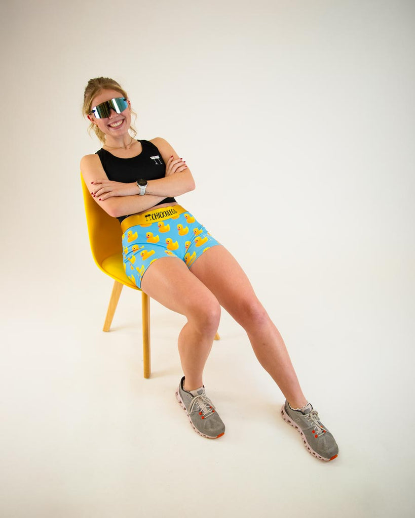 Runner is wearing ChicknLegs in the women's 3 in compression spandex shorts with no pockets. The print has yellow rubber ducky on it with a blue background posing with sunglasses and a chair.