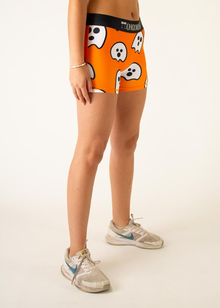 Model is a runner wearing Chicknlegs women's 3" compression shorts in the Ghost design, facing right.