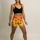 Full body front view of runner wearing the women's orange traffic cone compression shorts.