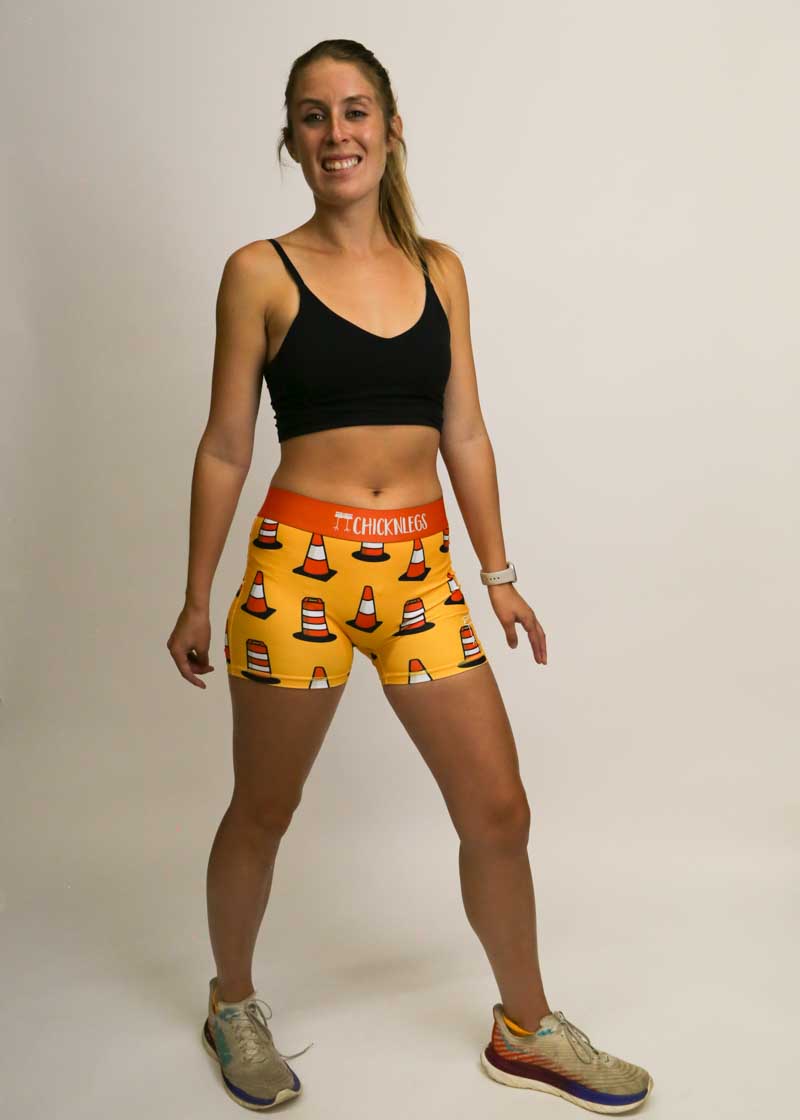 Full body front view of runner wearing the women's orange traffic cone compression shorts.