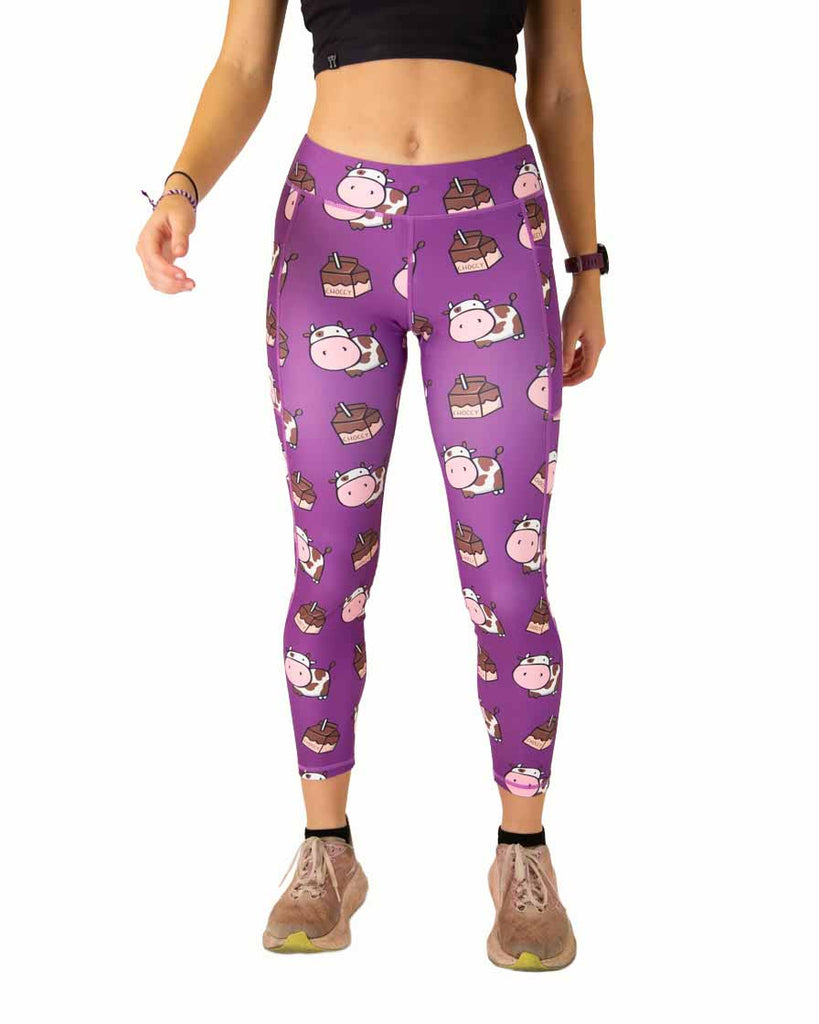 Runner is wearing ChicknLegs in the women's drawstring leggings with pockets in the choccy cow design. The print has brown and white cows with chocolate milk on a purple background.