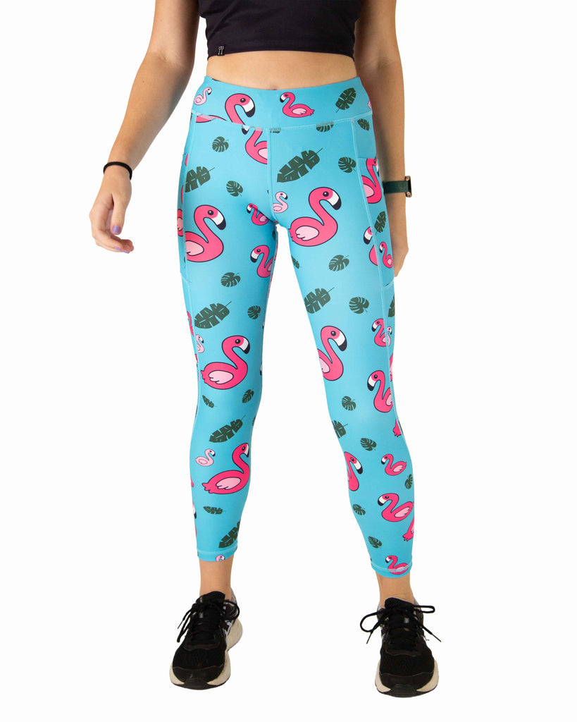 Runner is wearing ChicknLegs in the women's drawstring leggings with pockets in the blue flamingo design. The print has pink flamingos with green leaves on a blue background.