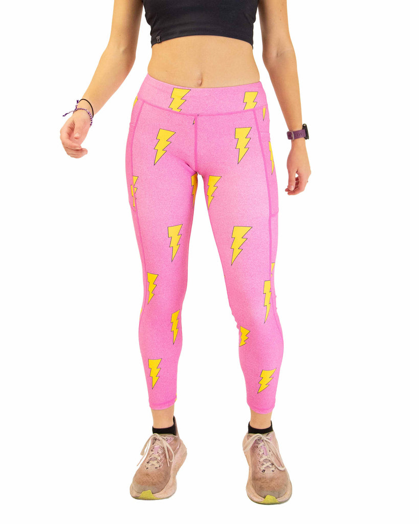Runner is wearing ChicknLegs in the women's drawstring leggings with pockets in the hot pink bolts design. The print has yellow lightning bolts on a hot pink background.