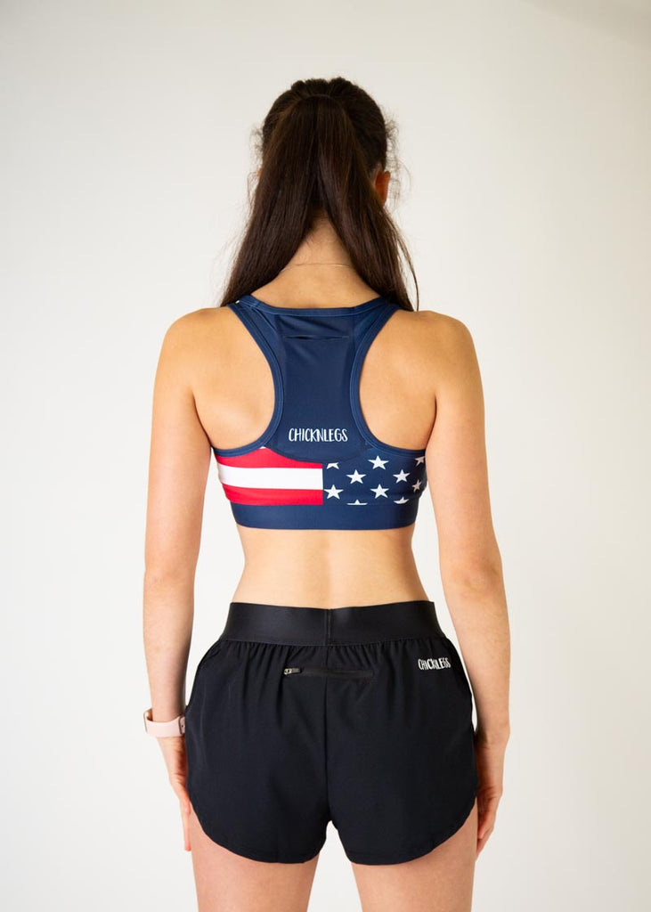 The model is a runner who is wearing Chicknlegs in the women's OG sports bra, in the USA design, facing away from the camera to show the back of the sports bra.