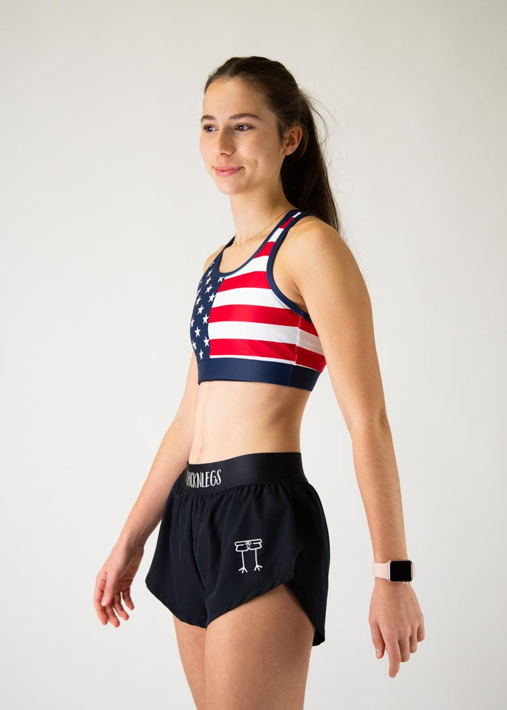 The model is a runner who is wearing Chicknlegs in the women's OG sports bra, in the USA design, facing left.