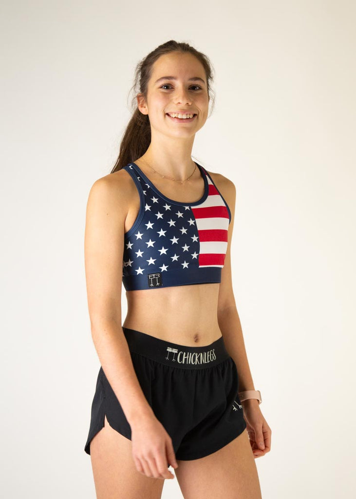 The model is a runner who is wearing Chicknlegs in the women's OG sports bra, in the USA design, facing right.