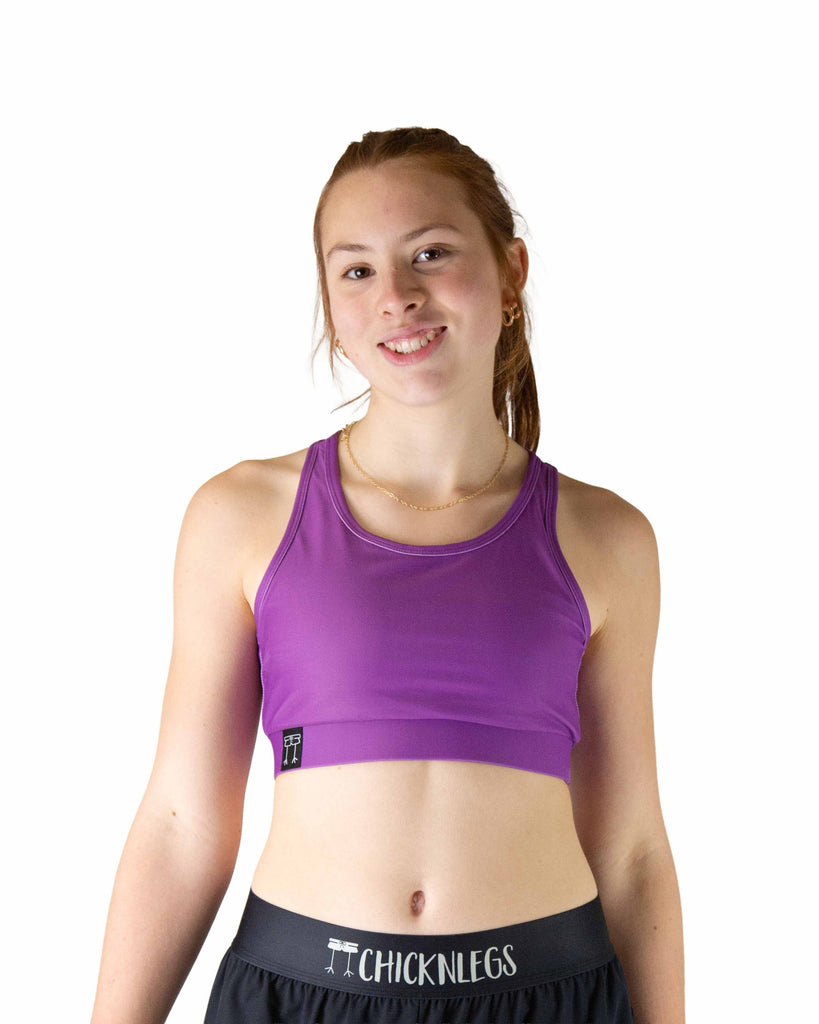 Runner is wearing ChicknLegs in the women's OG Sports Bra has a back pocket for exercise, running, workout, gym, and every day lifestyle. The print is the deep purple solid color. Great for matching with the choccy cow shorts.