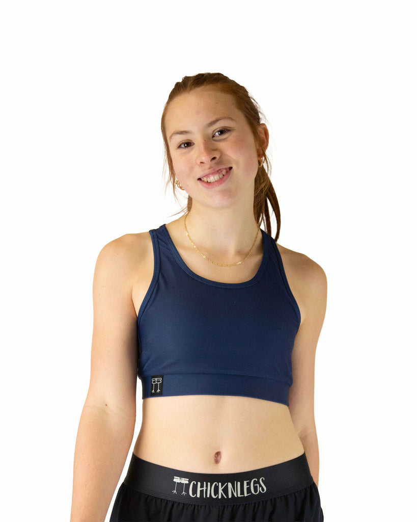 Runner is wearing ChicknLegs in the women's OG Sports Bra has a back pocket for exercise, running, workout, gym, and every day lifestyle. The print is the solid navy color.