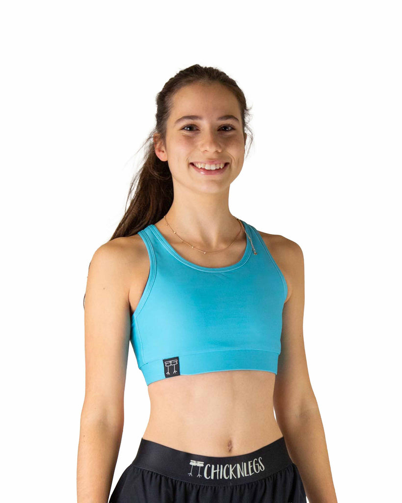 Runner is wearing ChicknLegs in the women's OG Sports Bra has a back pocket for exercise, running, workout, gym, and every day lifestyle. The print is the solid sky blue design, great for matching with the blue flamingo.