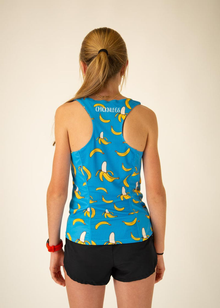 The model is a runner who is wearing Chicknlegs women's performance singlet in the blue banana design, facing away from the camera to show the back.