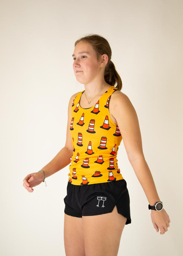 The model is a runner who is wearing Chicknlegs women's performance singlet in the traffic cones design, facing left.