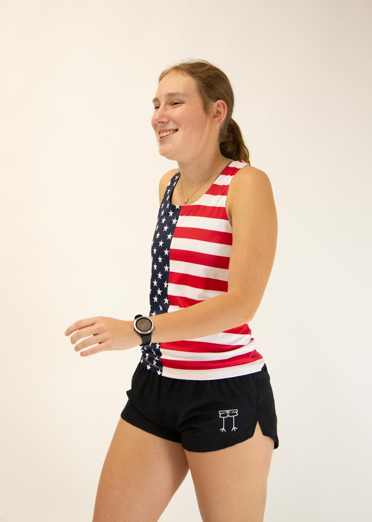 The model is a runner who is wearing Chicknlegs women's singlet in the USA design, facing left.