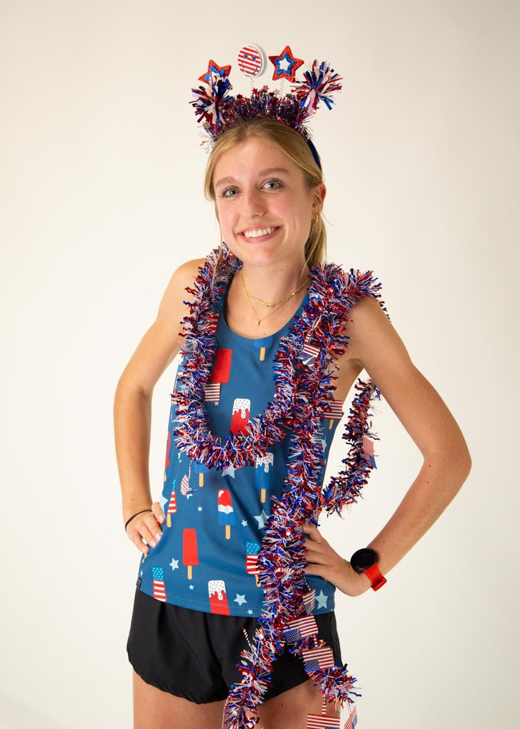Runner is wearing ChicknLegs in the women's performance singlet in the USA Popsicle singlet. The print has ice cream all over it in red white and blue dressed up for the American Flag fourth of july event.