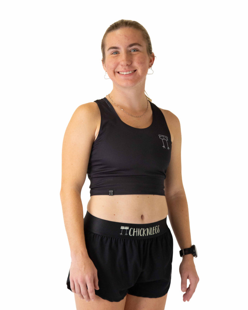 Runner is wearing ChicknLegs in the women's power crop top in the solid black design. The material is lightweight and soft.