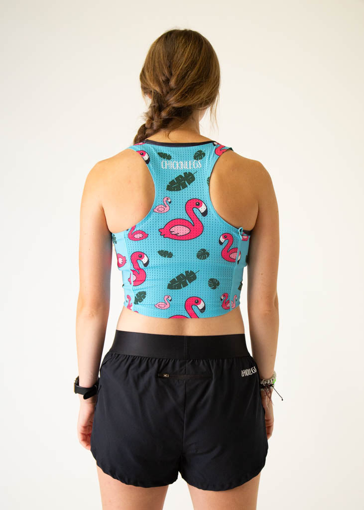 The model is a runner who is wearing Chicknlegs PWR crop top, in the blue flamingo design, facing away from the camera to show the back of the crop top.