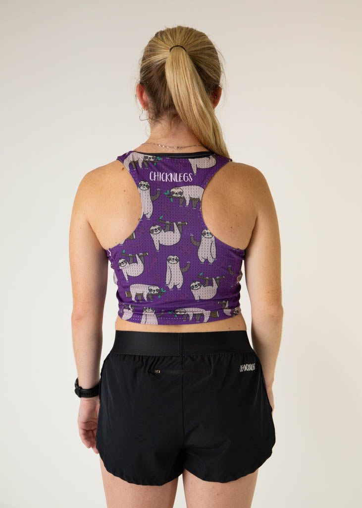 The model is a runner who is wearing Chicknlegs PWR crop top in the sloths design, facing away from the camera to show the back.