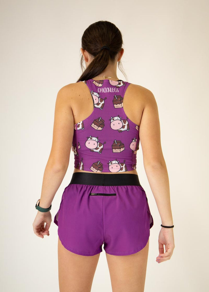 Runner is wearing ChicknLegs in the women's 1.5 in split running shorts in the deep purple design with the choccy cow PWR crop top. The outfit is a great matching fit.