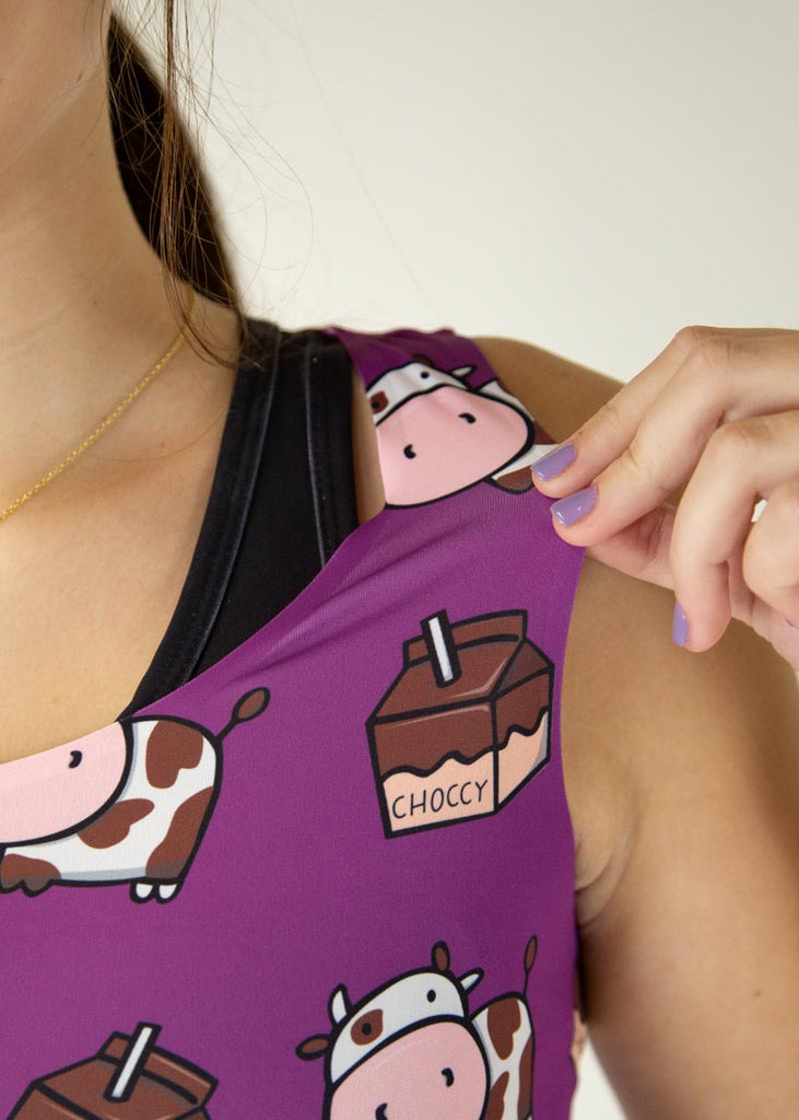 Runner is wearing ChicknLegs in the women's 1.5 in split running shorts in the deep purple design with the choccy cow PWR crop top. The outfit is a great matching fit.