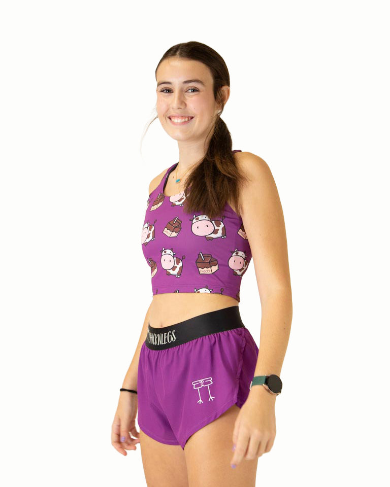Runner is wearing ChicknLegs in the women's 1.5 in split running shorts in the deep purple design with the choccy cow PWR crop top. The outfit is a great matching fit.