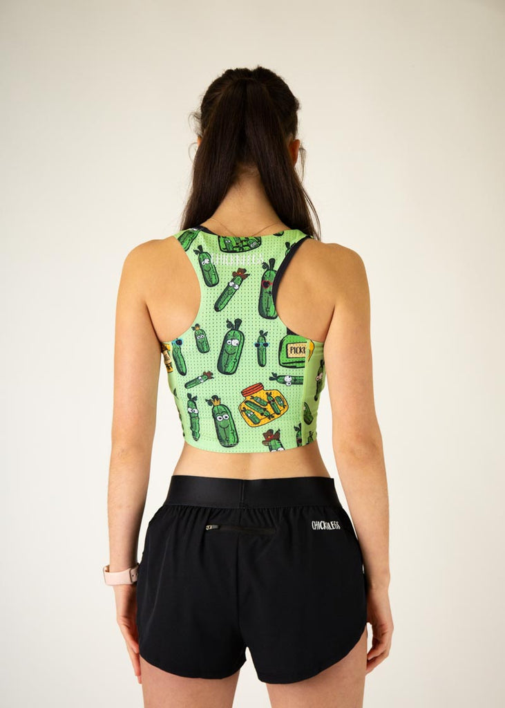 The model is a runner who is wearing Chicknlegs in the women's PWR crop top, in the pickles design, facing away from the camera to show the back of the crop top.