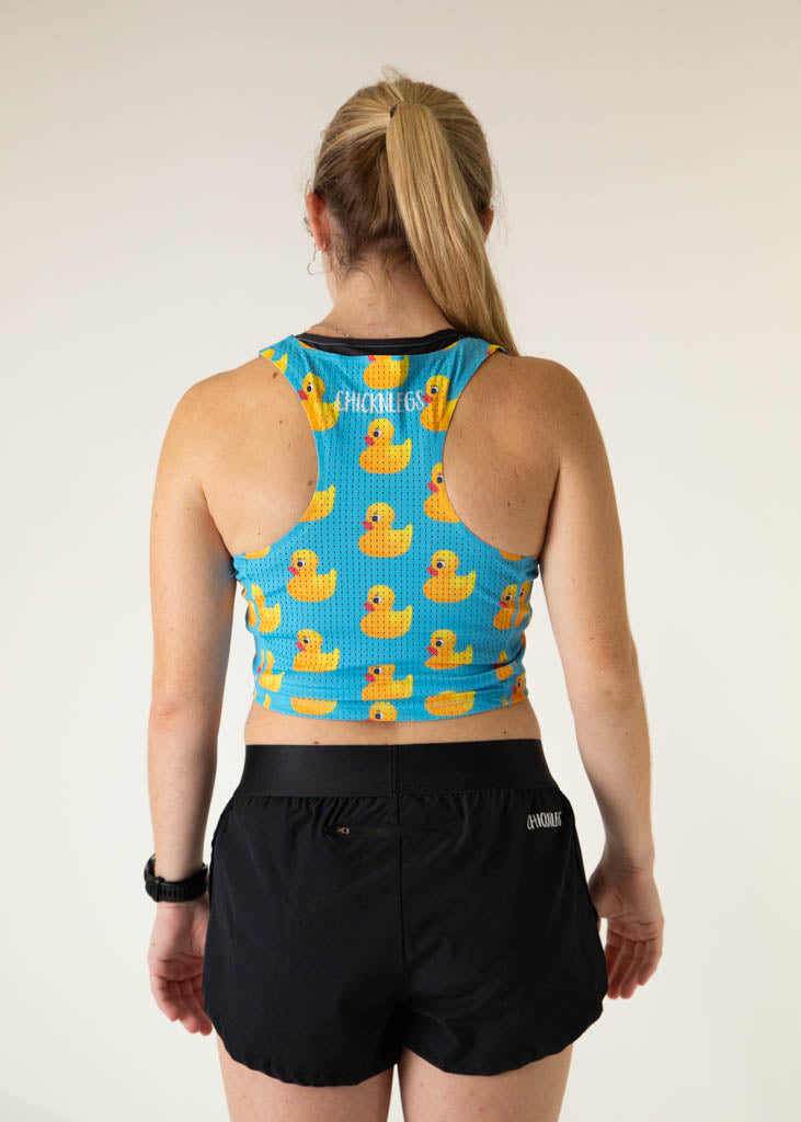 The model is a runner who is wearing Chicknlegs PWR crop top, in the rubber ducky design, facing away from the camera to show the back of the crop top.