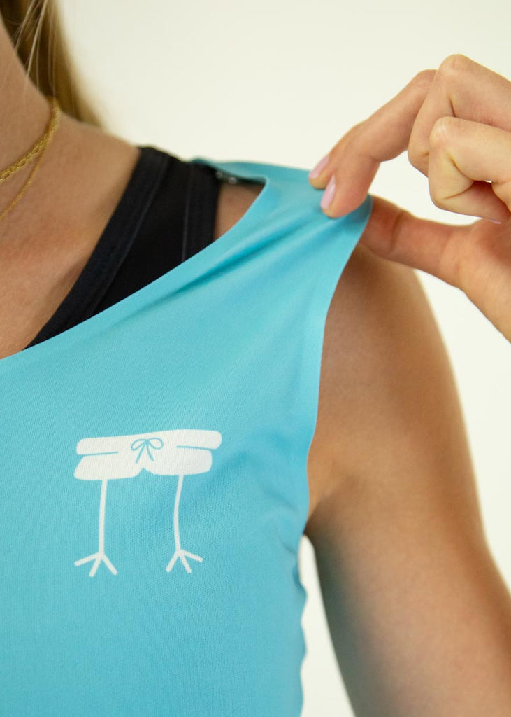 The model is holding the singlet by the arm hole to show how lightweight the fabric is for the pwr crop top.