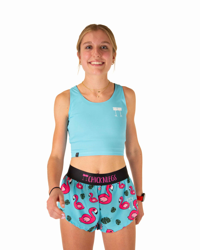 Runner is wearing ChicknLegs in women's power crop top in the sky blue design. The material is lightweight and the print is the solid blue color that matches with the blue flamingo design.
