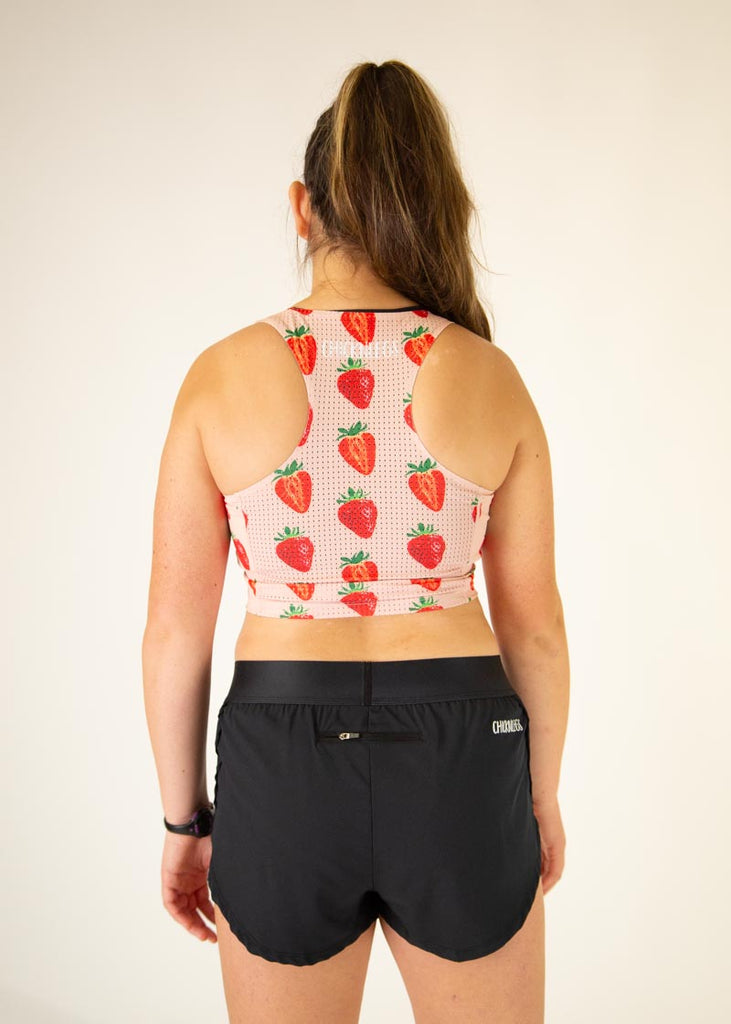 The model is wearing Chicknlegs women's pwr crop top in the strawberry szn design, facing away from the camera to show the front.