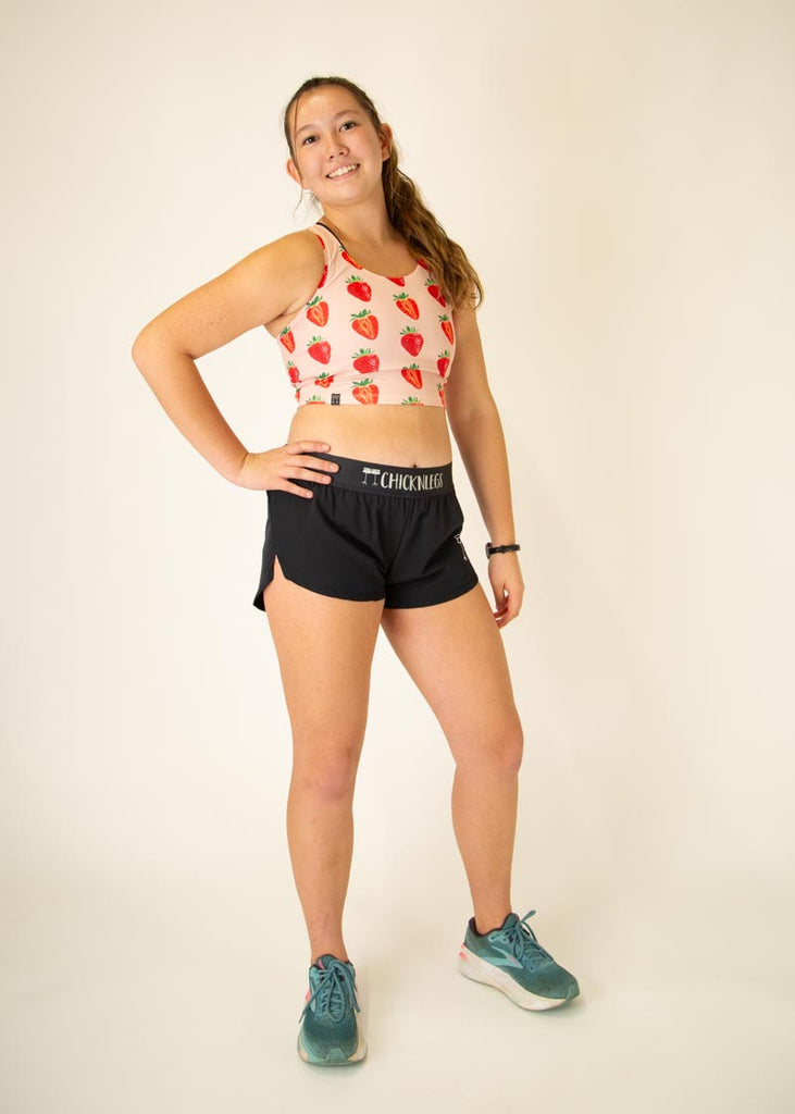 The model is wearing Chicknlegs women's pwr crop top in the strawberry szn design, facing front while posing to show the entire outfit.