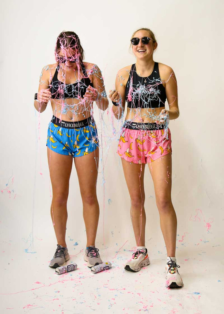 Runners covered in blue and pink silly string while wearing the ChicknLegs blue and pink banana running shorts.