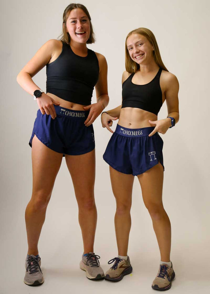 Runners showing off the ChicknLegs logo on the women's 1.5" navy blue split shorts.