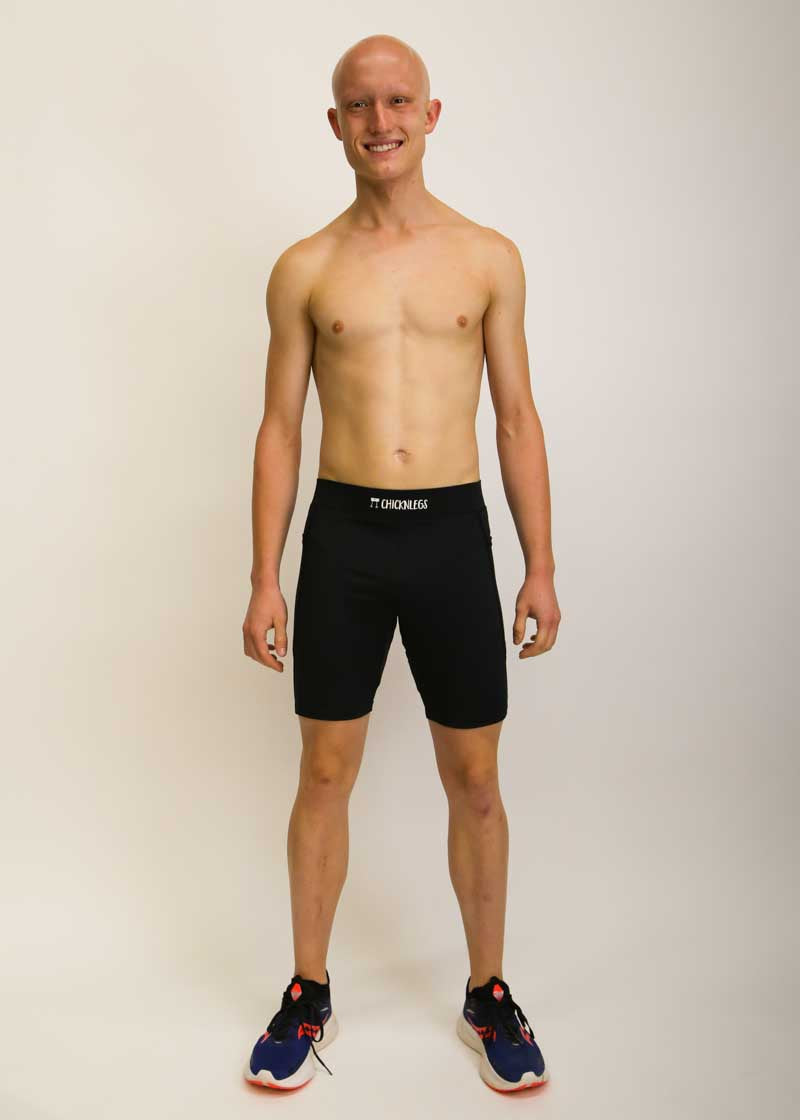 Full body view of runner wearing the men's 8 inch black half tights.