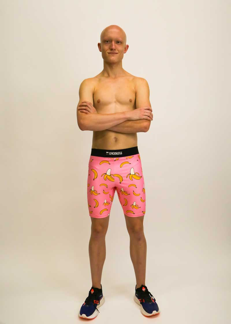 Runner wearing the men's 8 inch compression half tights with a pink bananas design.