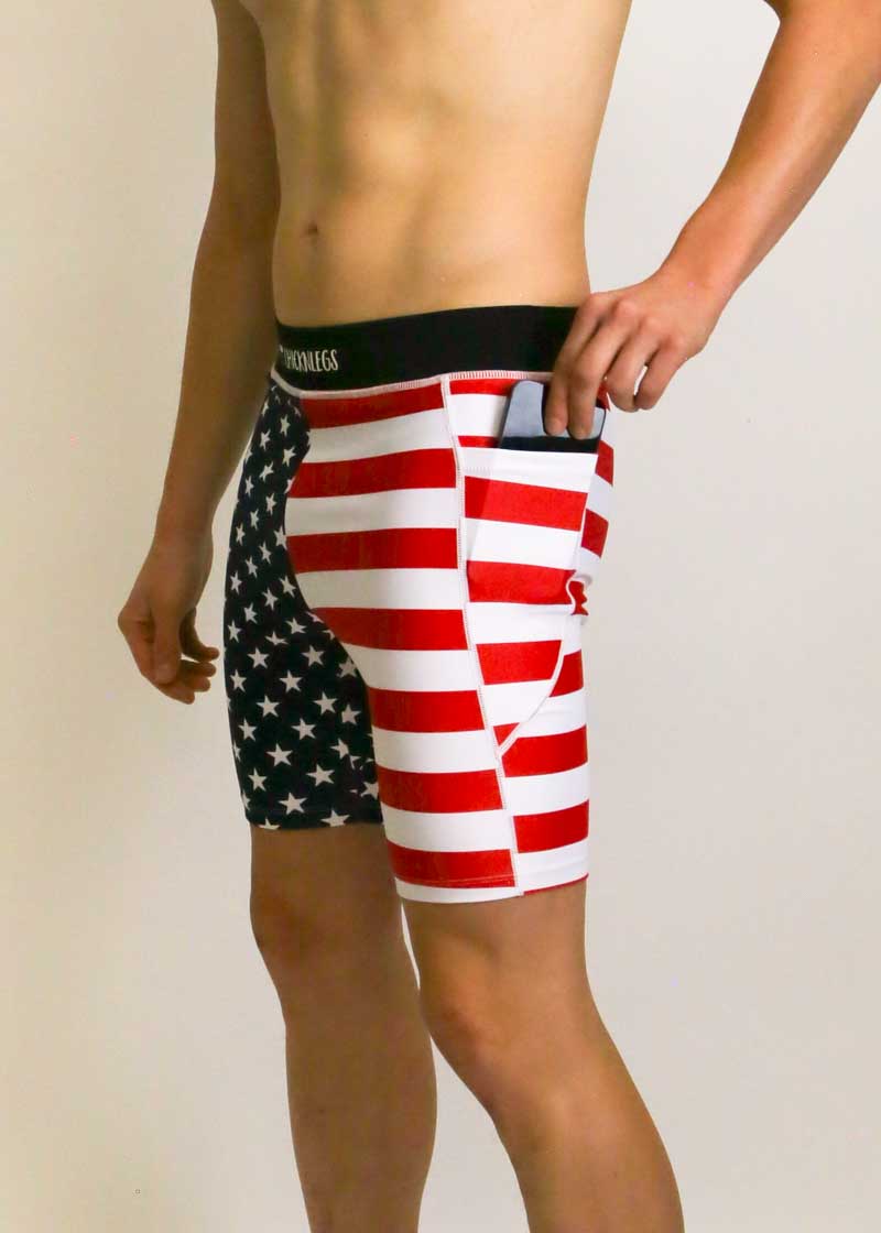 Side view of runner putting a phone in the pocket of the men's 8 inch USA half tights.