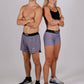 Full body group photo of the heather grey design in both the women's 3 inch compression shorts and the men's 4 inch half split running shorts.