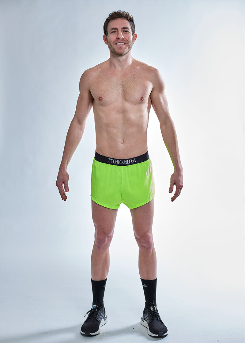 Full body view of the ChicknLegs men's 2 inch neon green split running shorts.