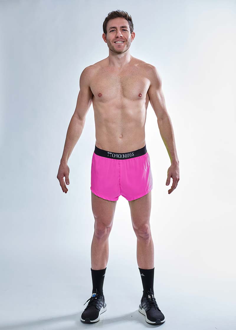 Full body view of the men's neon pink 2 inch split running shorts.