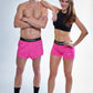 Full body group photo of the men's neon pink 2 inch split shorts and women's 3 inch compression shorts.