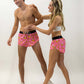 Group shot of runners laughing wearing the men's and women's pink bananas running shorts.
